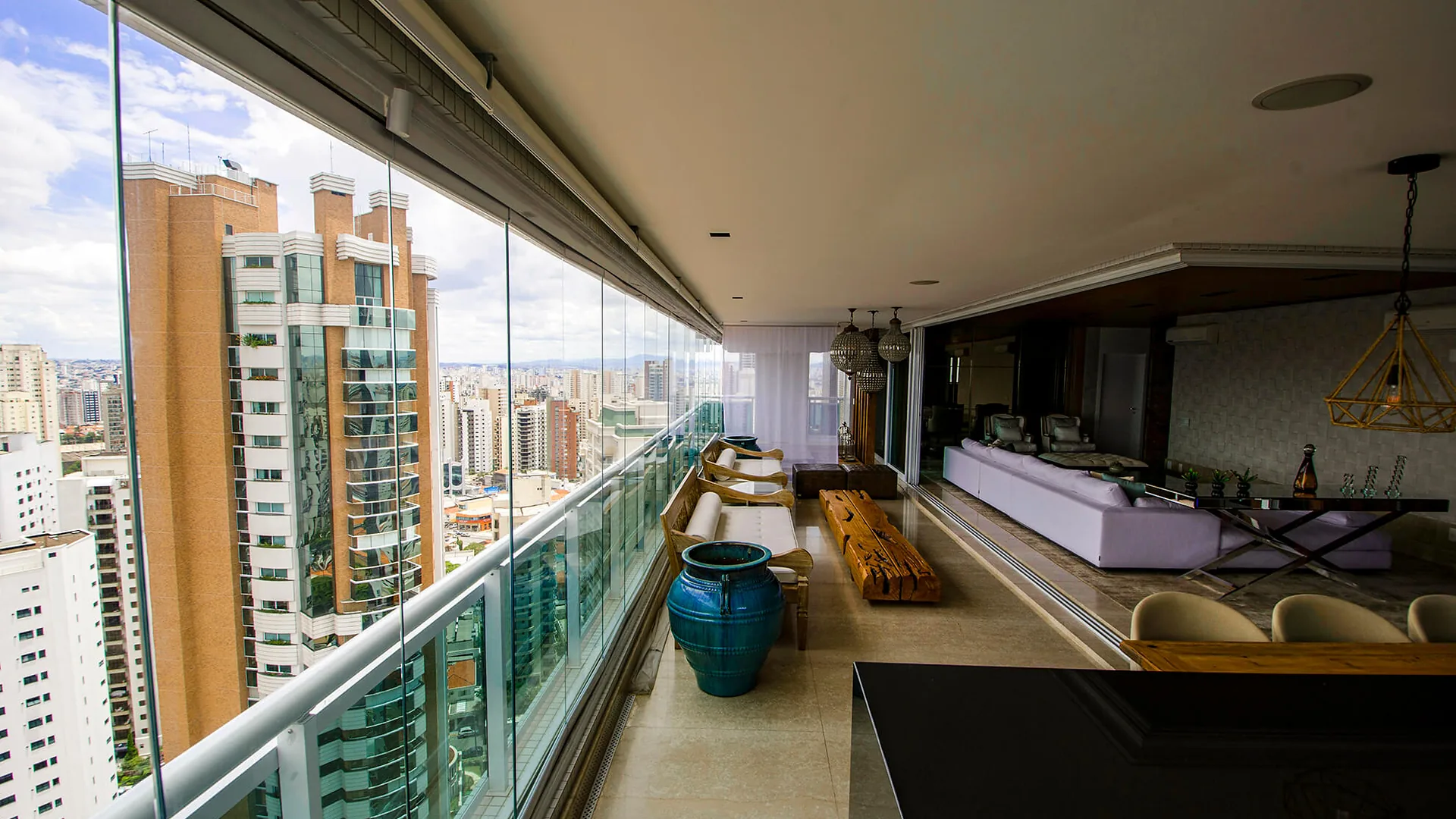 Cerramiento FlexiGlass de vidrio templado a lo largo del balcón corrido de un apartamento con vista a la ciudad